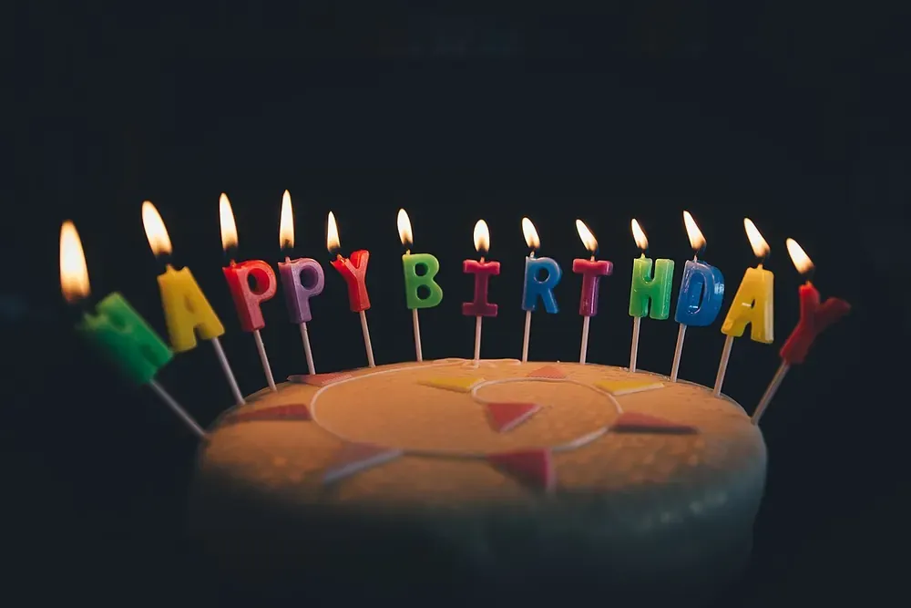 插着彩色 Happy Birthday 字母蜡烛的生日蛋糕