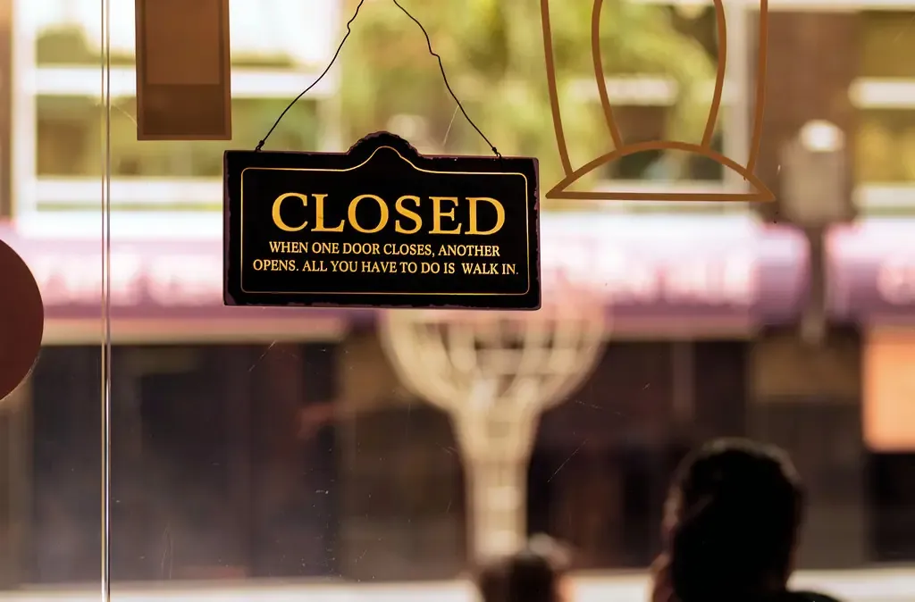 挂在店铺玻璃门上的 CLOSED 牌子