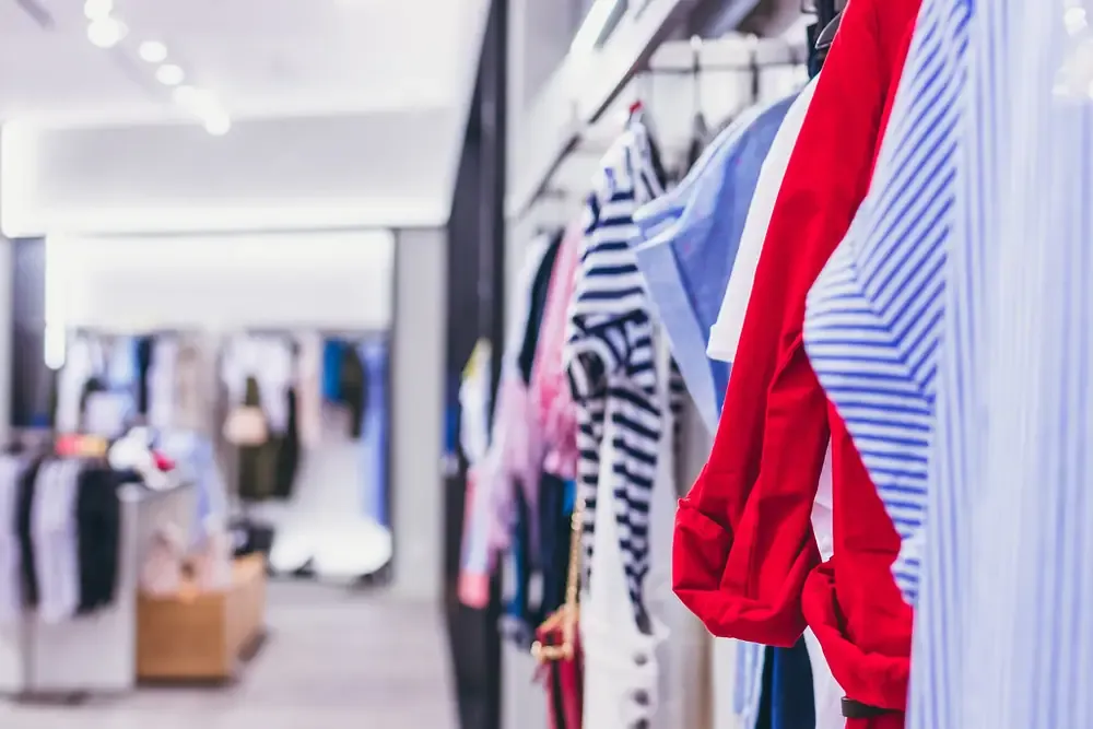 明亮服装店里挂着的条纹衬衫和红色上衣