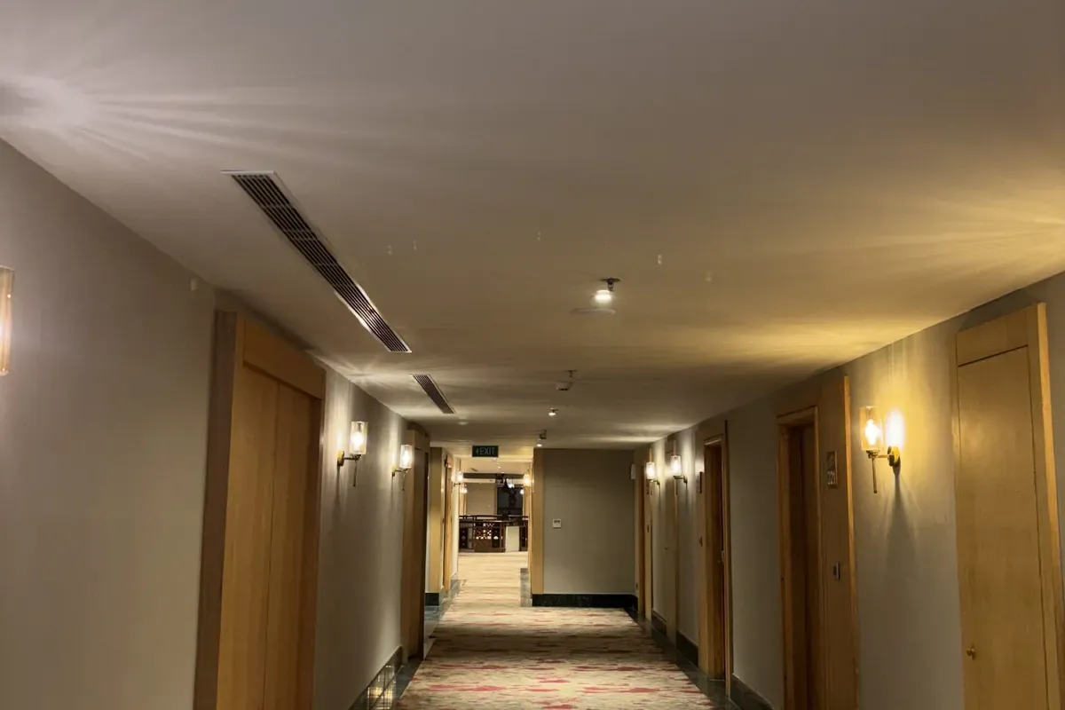 ทางเดินโรงแรมปูพรมพร้อมไฟผนังโทนอุ่น