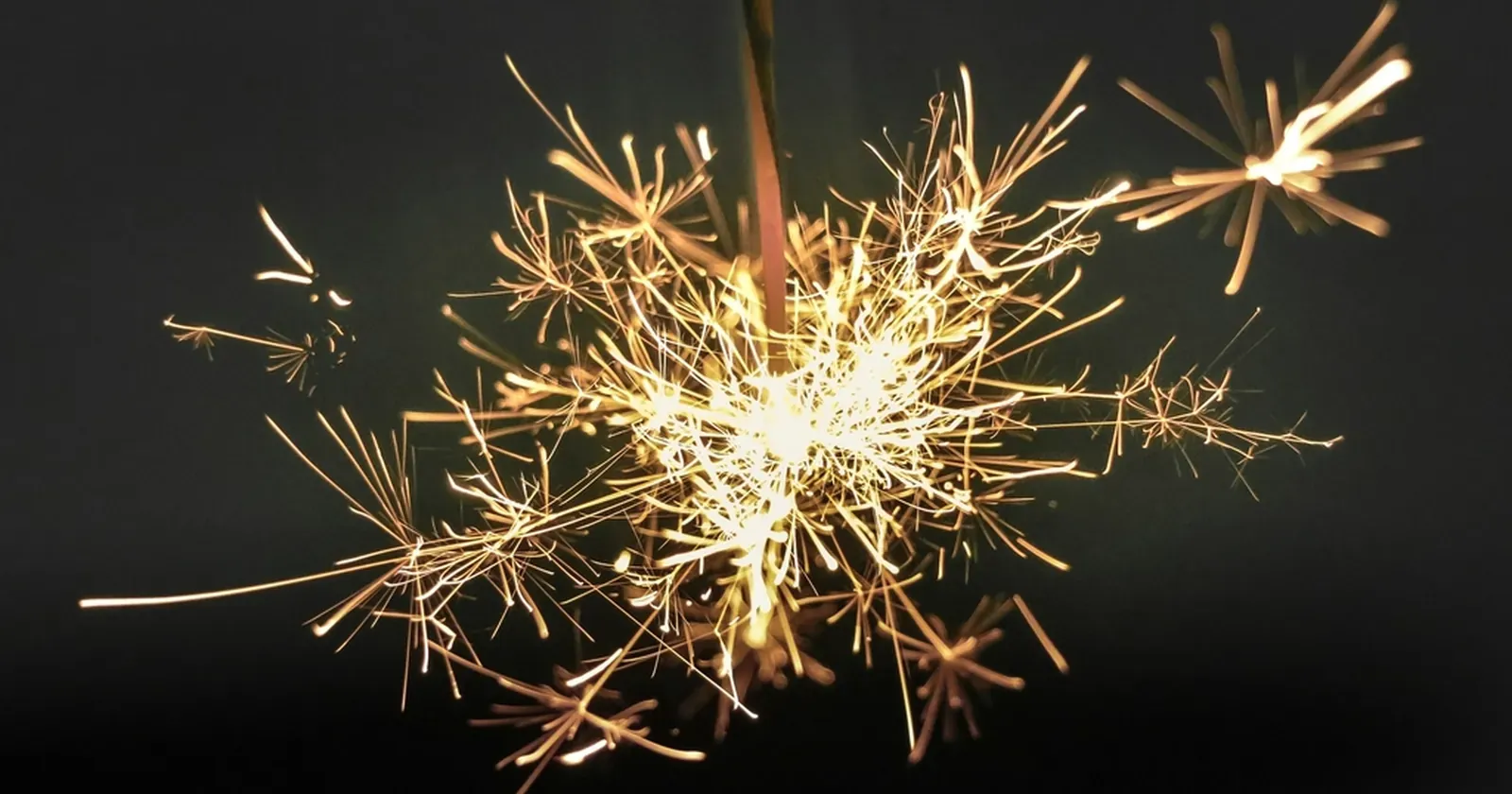暗い背景に火花を散らす手持ち花火