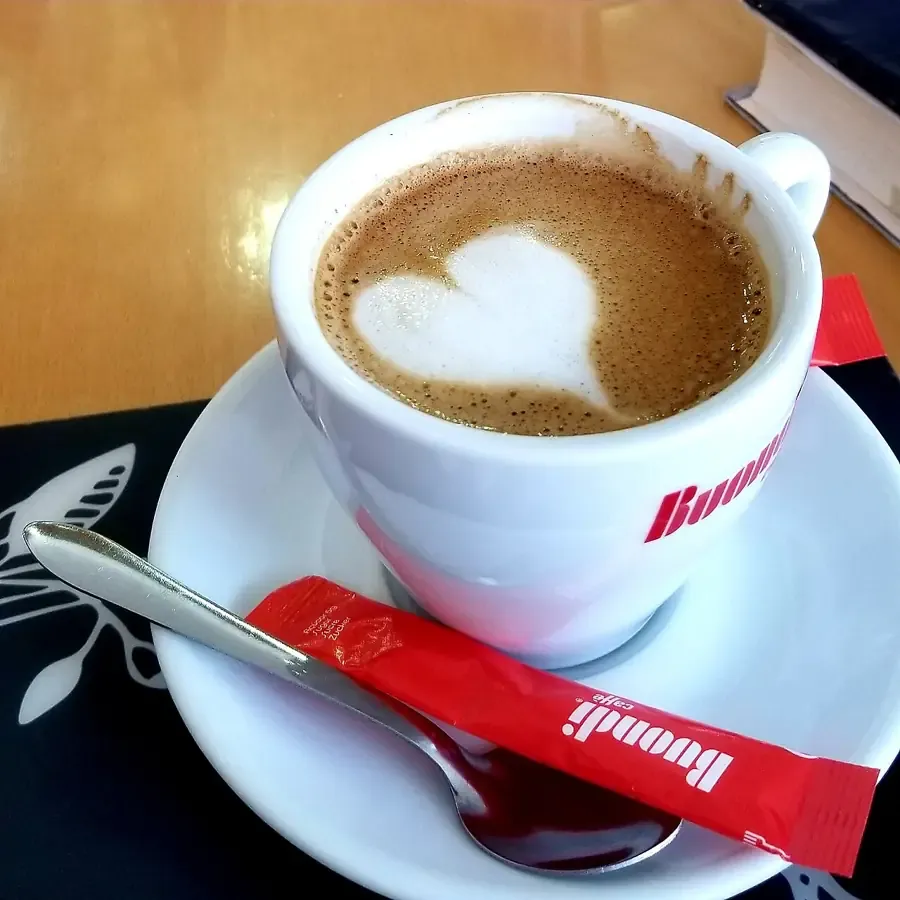Secangkir kopi susu dengan gambar hati di busanya