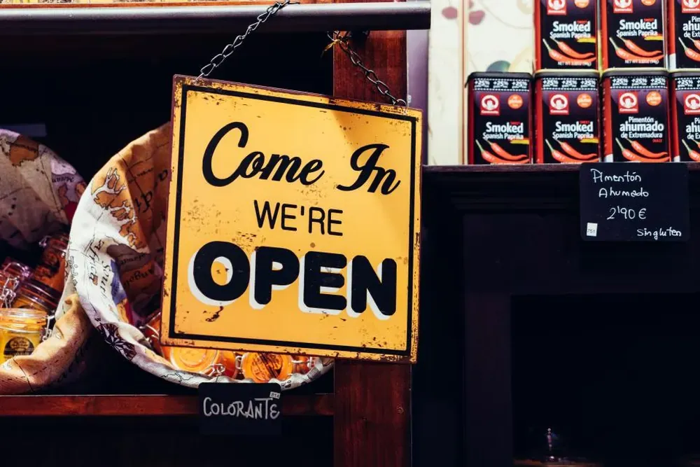 店门口挂着写有 Come in we're open 的黄色牌子