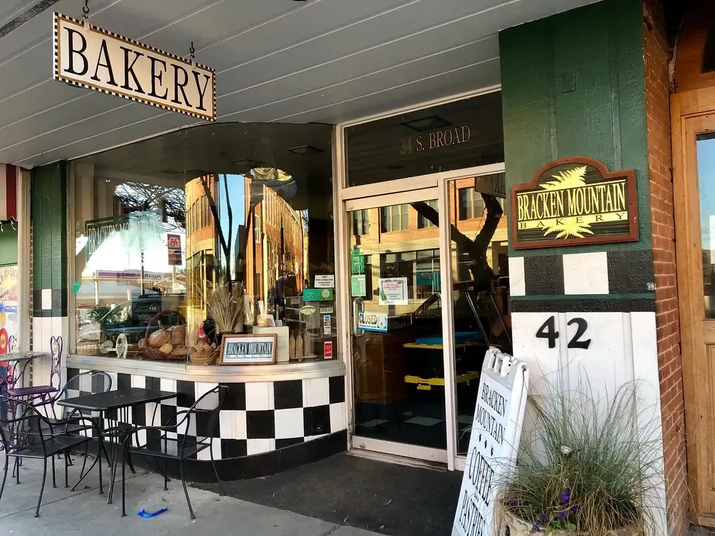 หน้าร้านเบเกอรี่ที่มีป้าย Bakery เลขที่ 42 และโต๊ะเก้าอี้หน้าร้าน